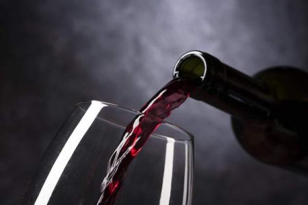 Mousserande rött vin som hälls upp i ett vinglas